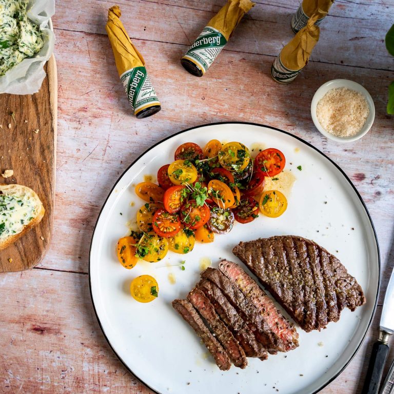 Steak with herb butter, tomato salad and baguette