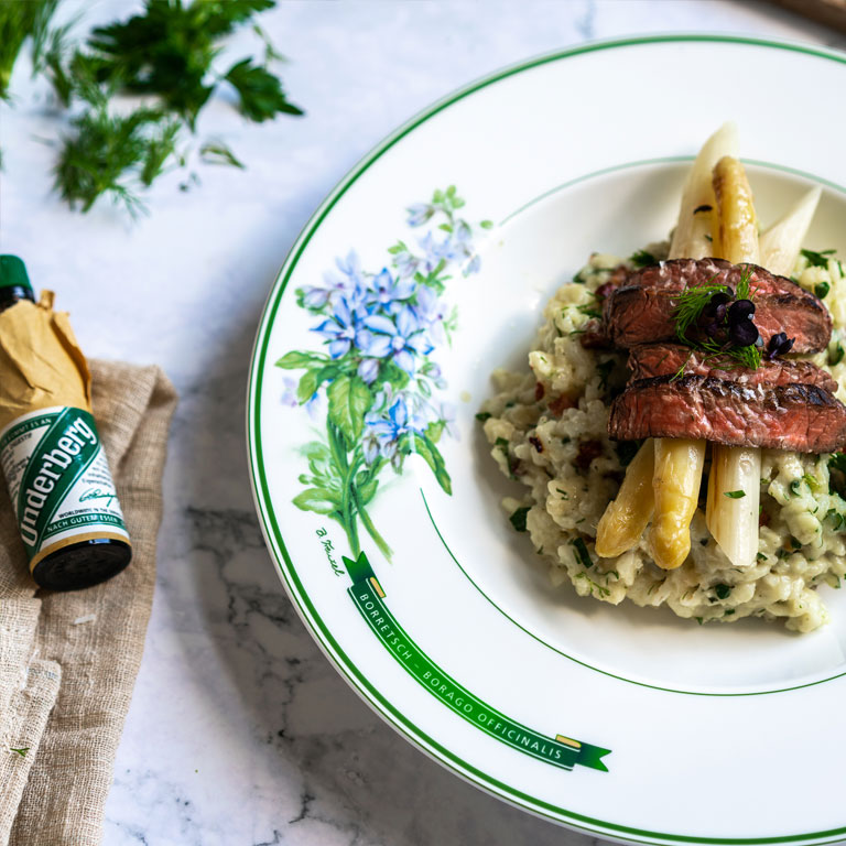 Herb-bacon risotto with white asparagus and beef strips
